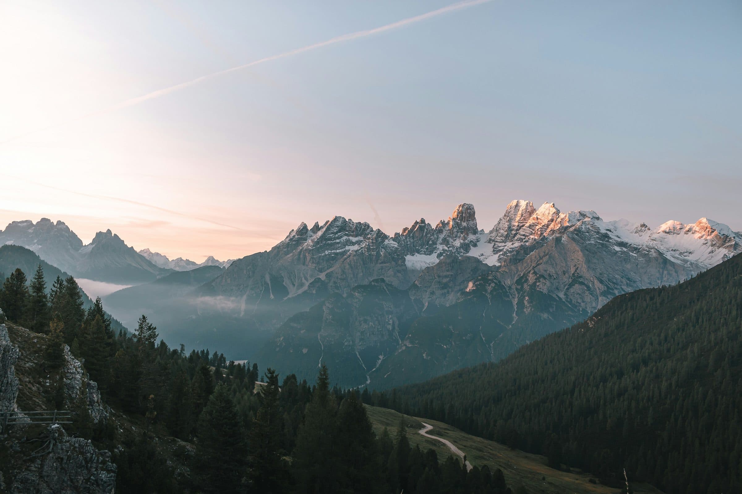 Montañas nevadas sobre un bosque al amanecer